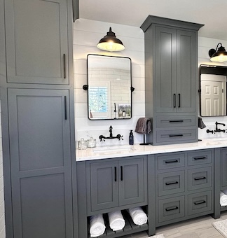 Stylish bathroom with gray cabinets and dual sinks. Black fixtures pop against white counters.